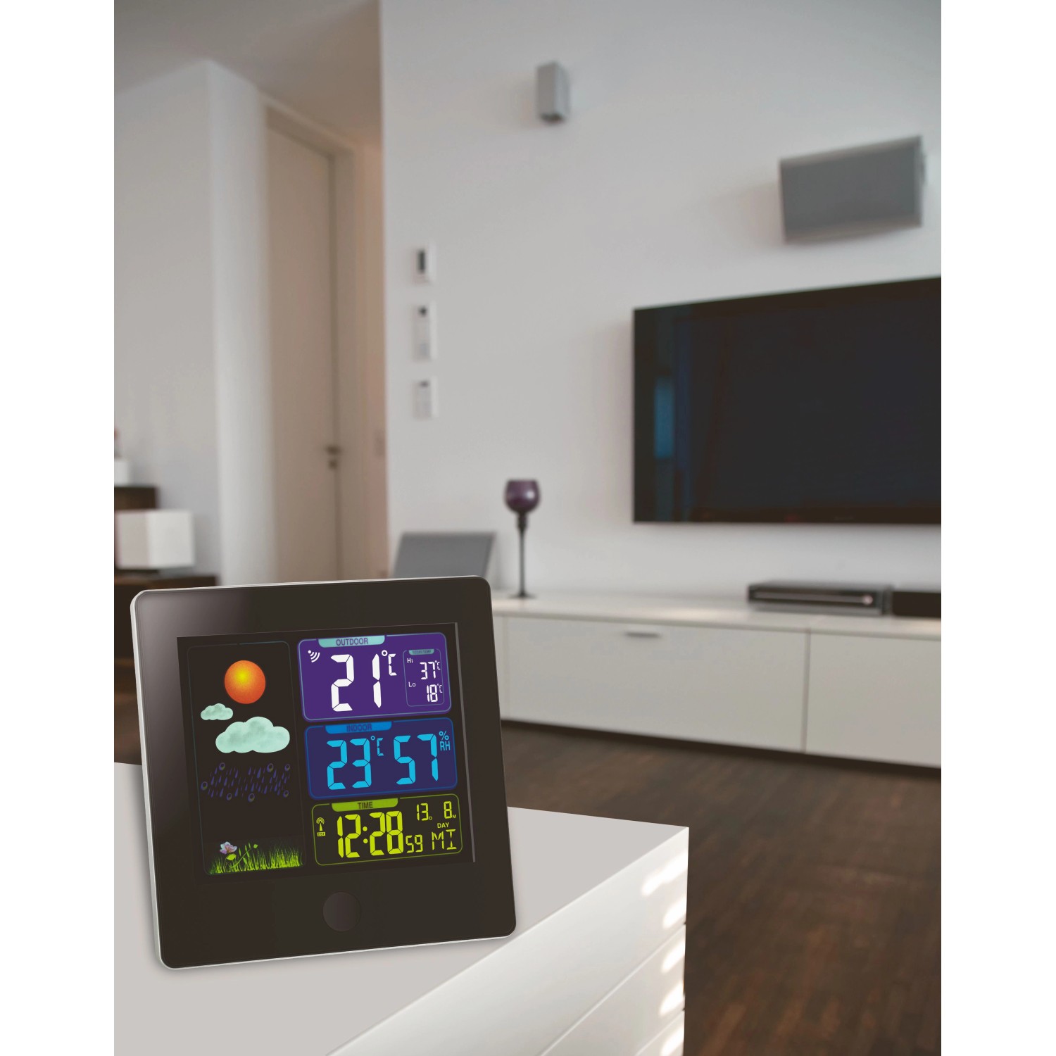 Schwarze TFA Funk-Wetterstation Sun mit Farbdisplay und Wettervorhersage im Wohnzimmer.