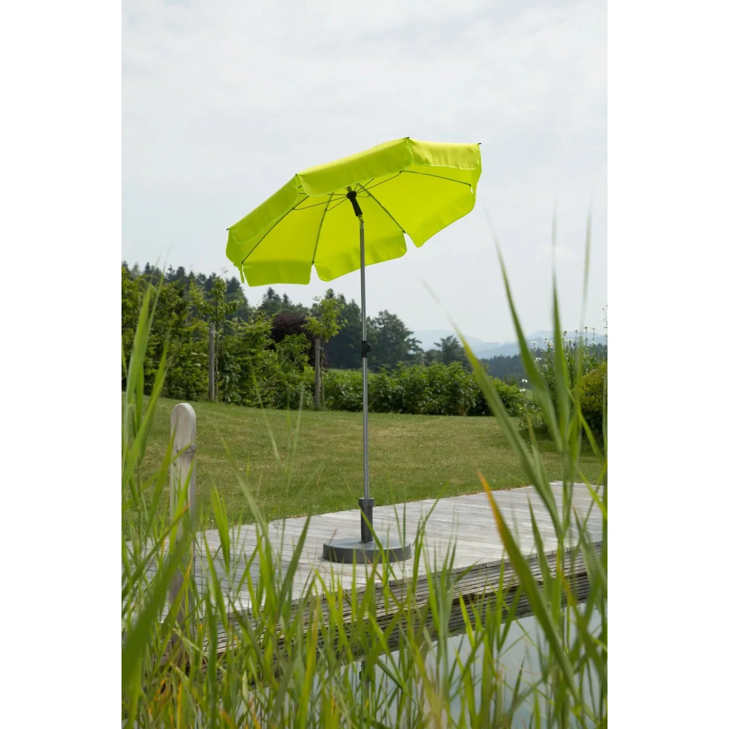 Apfelgrüner Schneider Balkonschirm Locarno Ø 150 cm mit Push-Up Mechanik im Garten.