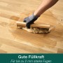 Auftragen von Bona Parkett Fugenkitt auf einen Holzboden mit einem Spachtel.