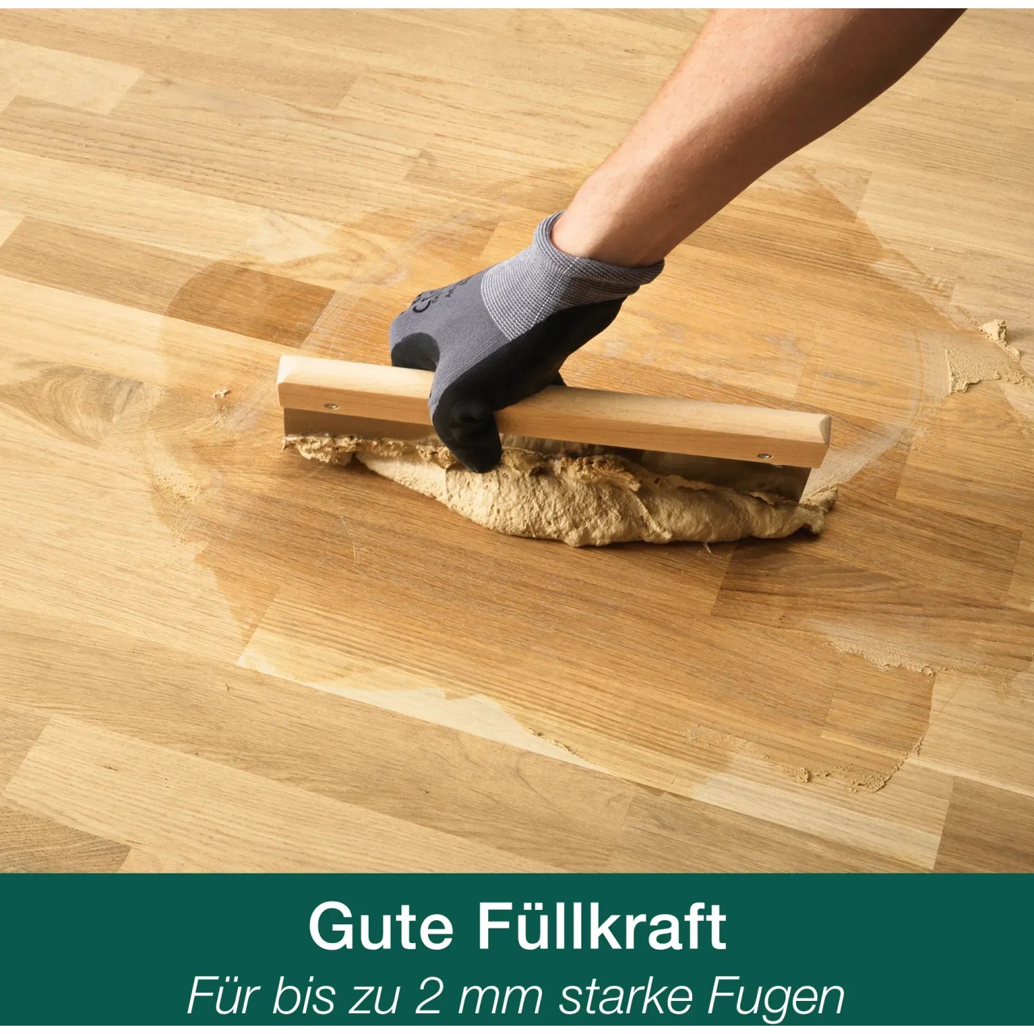 Auftragen von Bona Parkett Fugenkitt auf einen Holzboden mit einem Spachtel.