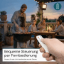Szene mit LUXULA LED Solarstrahler, Grill und Personen. Fokus auf Fernbedienung.