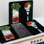 Wenko Herdabdeckplatten Caprese 2er Set mit Tomaten, Mozzarella und Basilikum auf schwarzem Hintergrund.