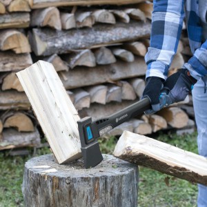 Gardena Universalaxt 1400A beim Holzspalten auf Hackklotz vor Holzstapel.