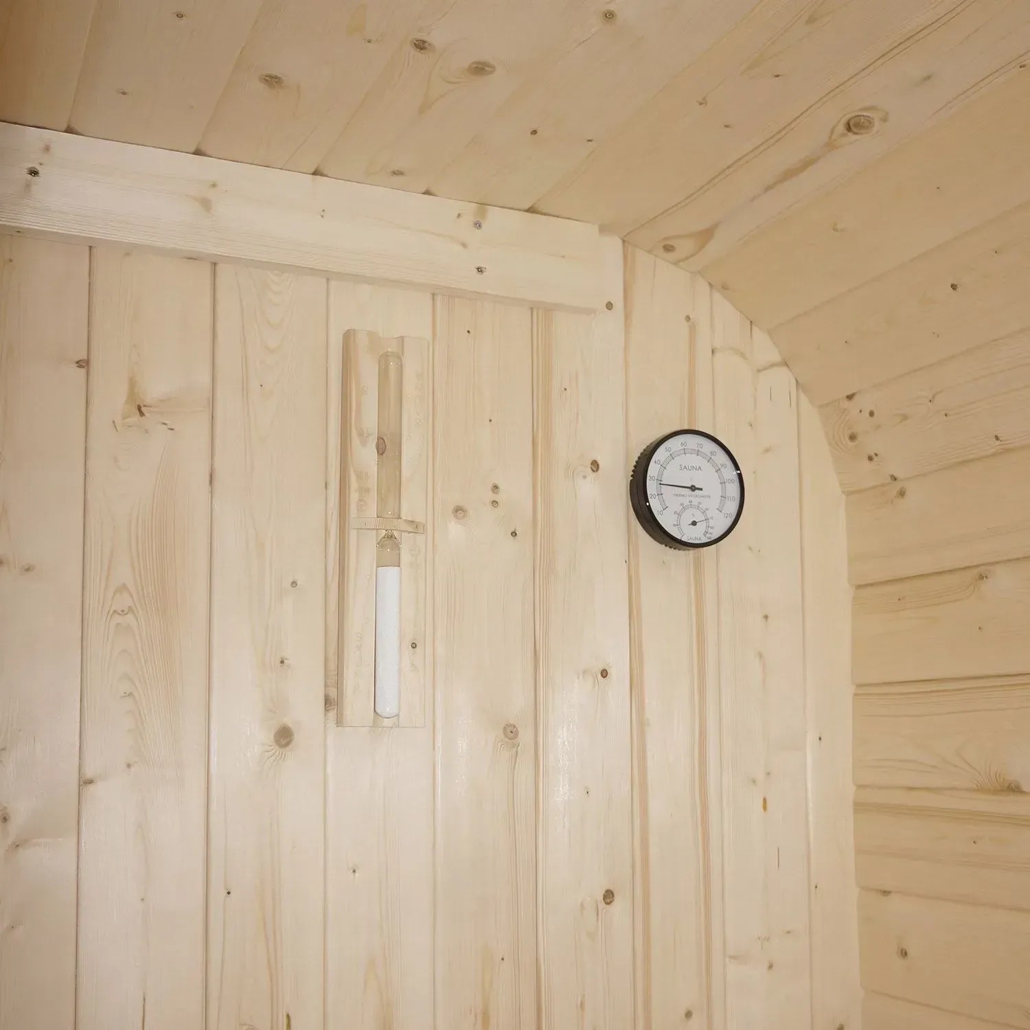 Innenansicht Artsauna Cube Fasssauna Nolvik M: Thermometer und Sanduhr an Holzwand.