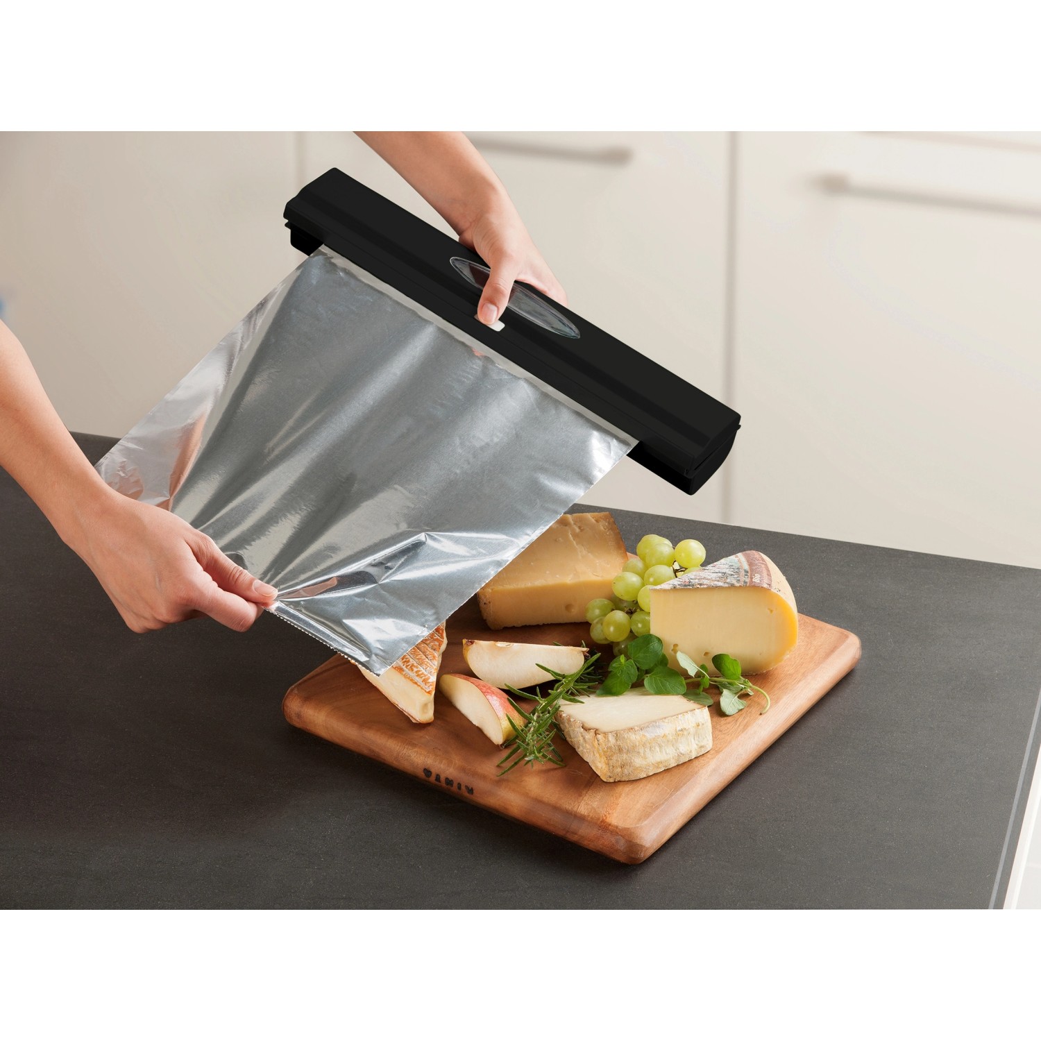 Wenko Folienspender Perfect Cutter Black Outdoor Kitchen, Folie wird über Käse gezogen.