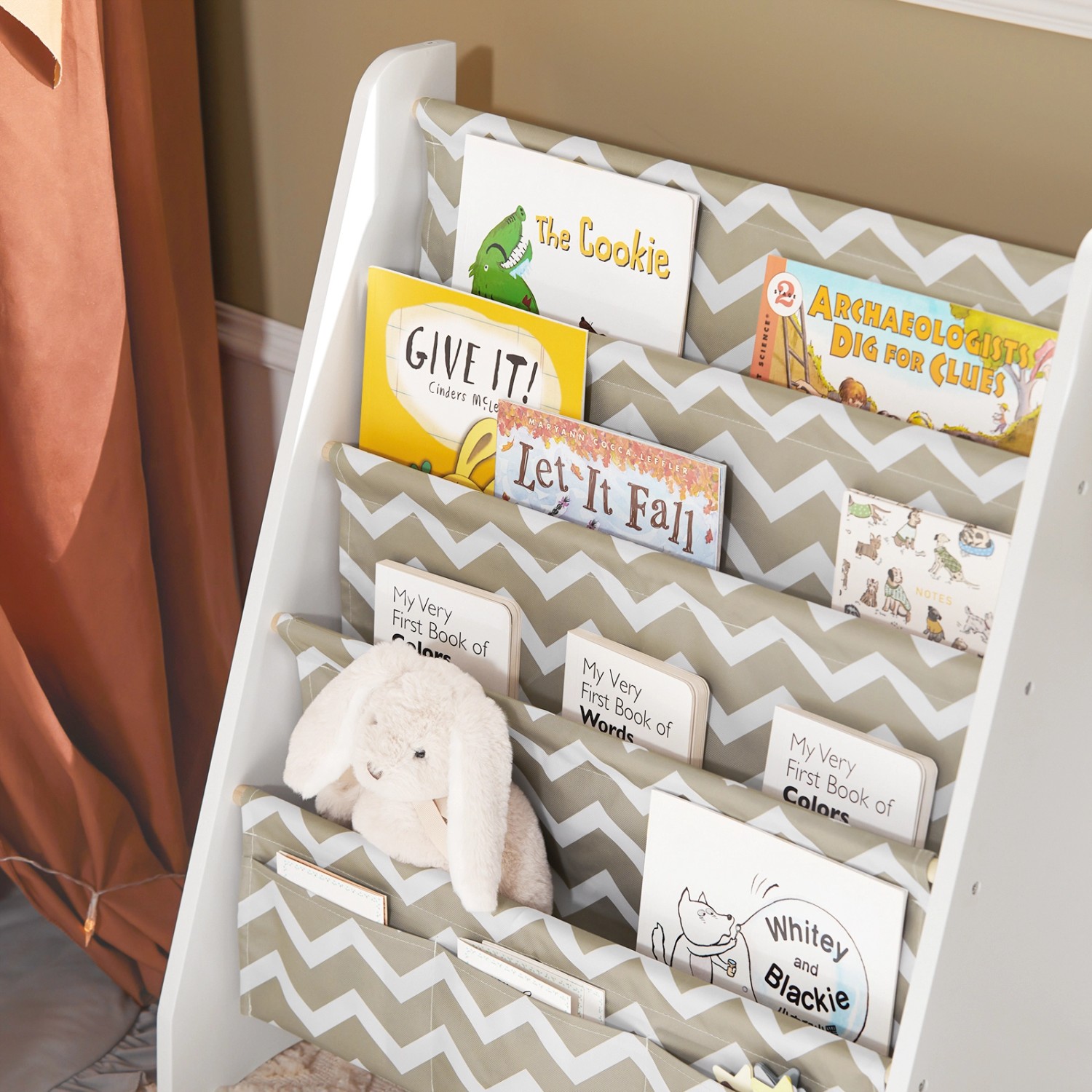 SoBuy Kinder-Bücherregal KMB50-HG mit Stofffächern in Grau/Weiß, gefüllt mit Büchern und einem Stofftier.