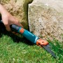 Gardena Comfort Grasschere beim Rasenkantenschneiden nahe eines Steins.