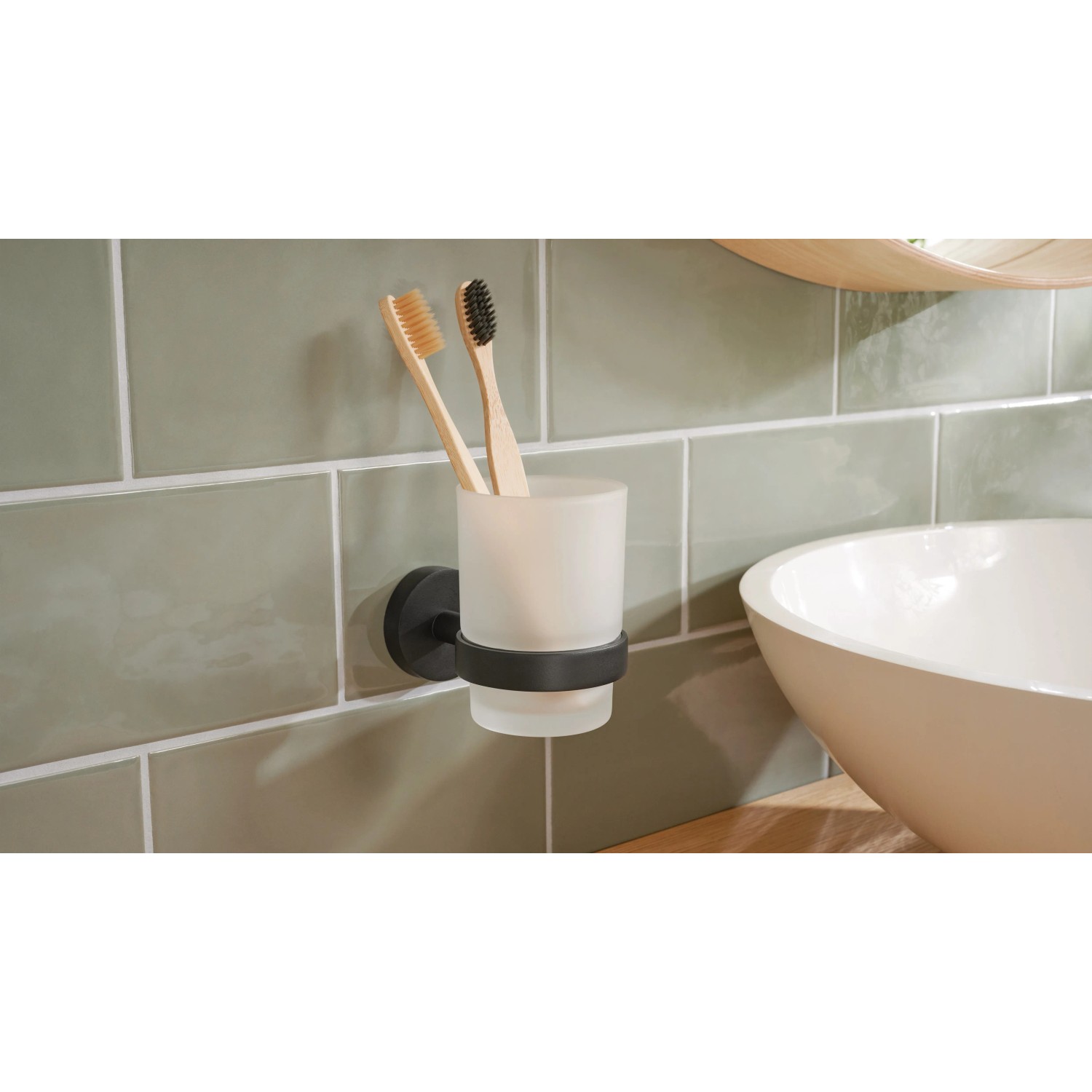Tesa Moon Black Zahnputzbecher mit Halter, schwarz matt und satiniertem Glas, an Wand montiert.