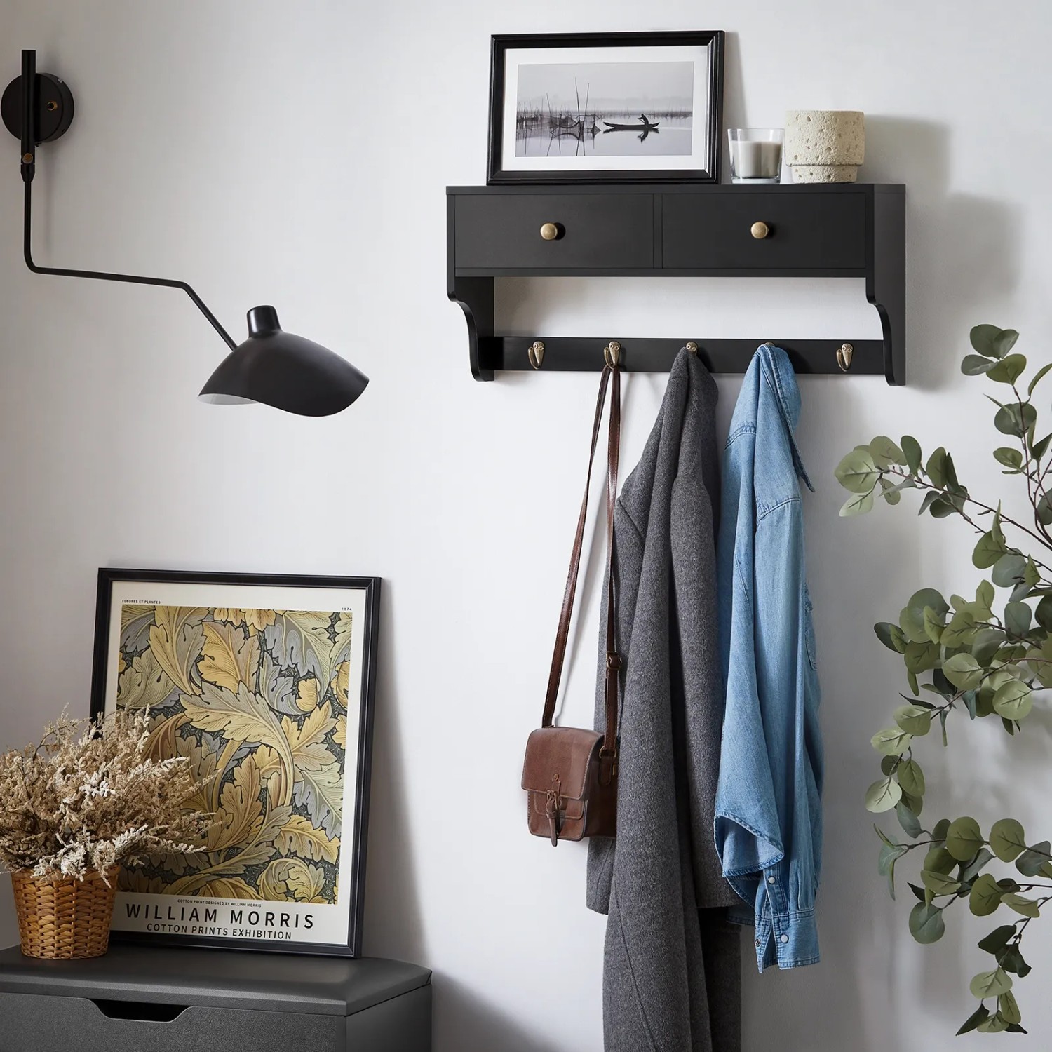 Schwarze SoBuy Wandgarderobe mit 2 Schubladen und 5 Haken an weißer Wand.
