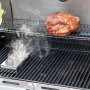 Char-Broil Räucherbox aus Edelstahl auf Grill mit Fleisch und Rauch.