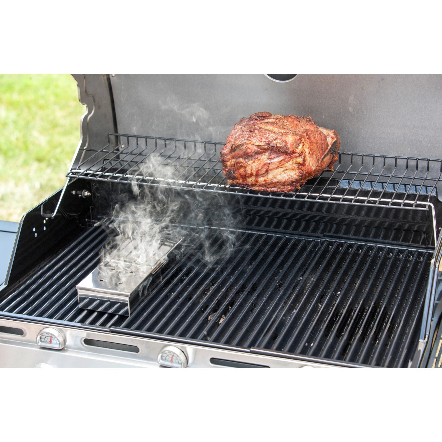 Char-Broil Räucherbox aus Edelstahl auf Grill mit Fleisch und Rauch.