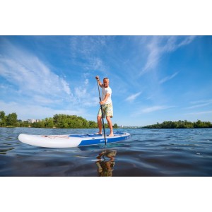 Mann auf blauem ZRAY Stand Up Paddle Board (SUP) mit Paddel auf dem Wasser.