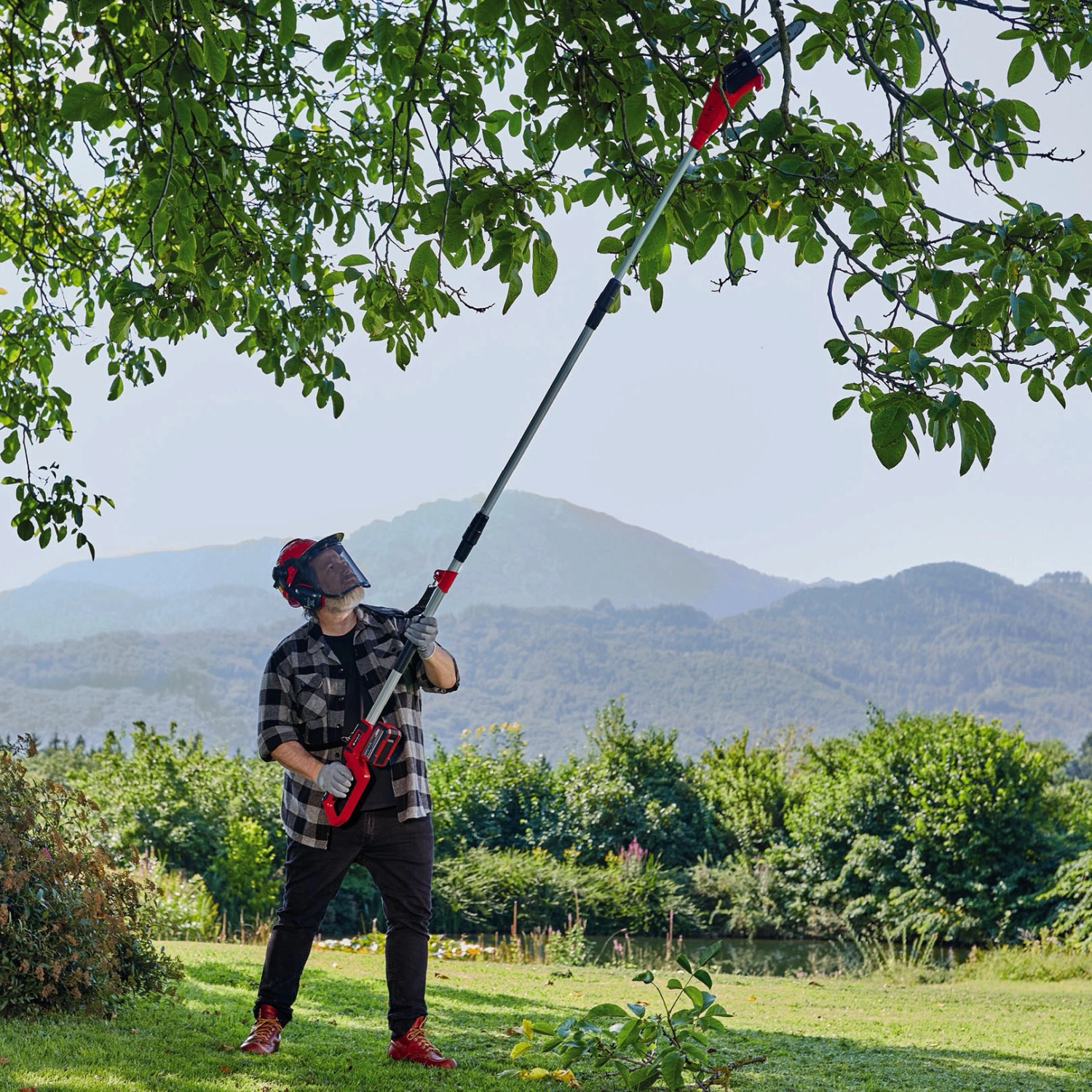Mann schneidet Äste mit dem Einhell Akku-Hochentaster GC-LC 18/20 Li T-Solo im Garten.