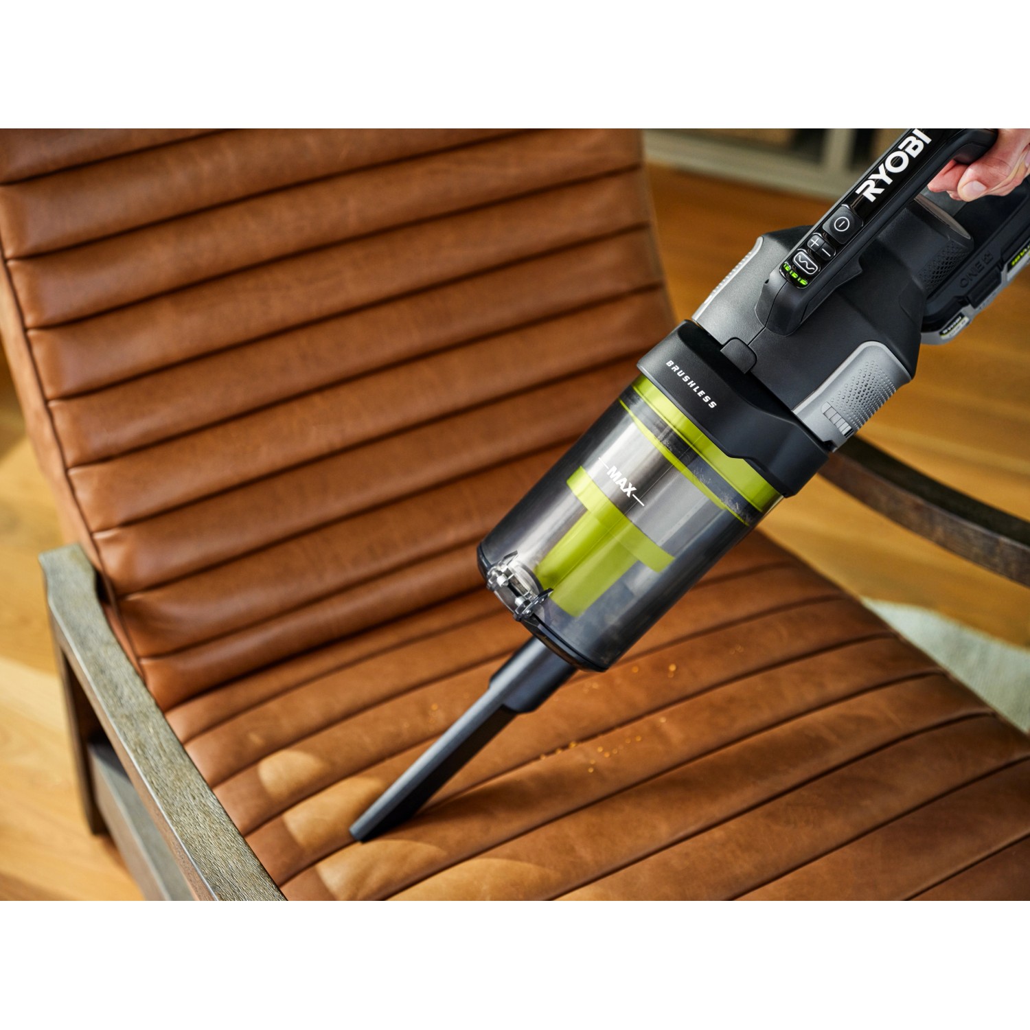 Ryobi Akku-Staubsauger One+ RASV18BL-0 beim Reinigen eines braunen Ledersessels.