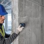 Handwerker misst mit Bosch Professional Laser-Entfernungsmesser GLM 40-31 eine Betonwand.