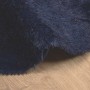 Detailansicht eines marineblauen Shaggy Hochflorteppichs aus Polyester auf hellem Holzfußboden. Weiche, dichte Textur.