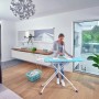 Frau bügelt Wäsche auf dem Leifheit AirBoard Compact M Plus Bügeltisch mit Thermo-Reflect Bezug.