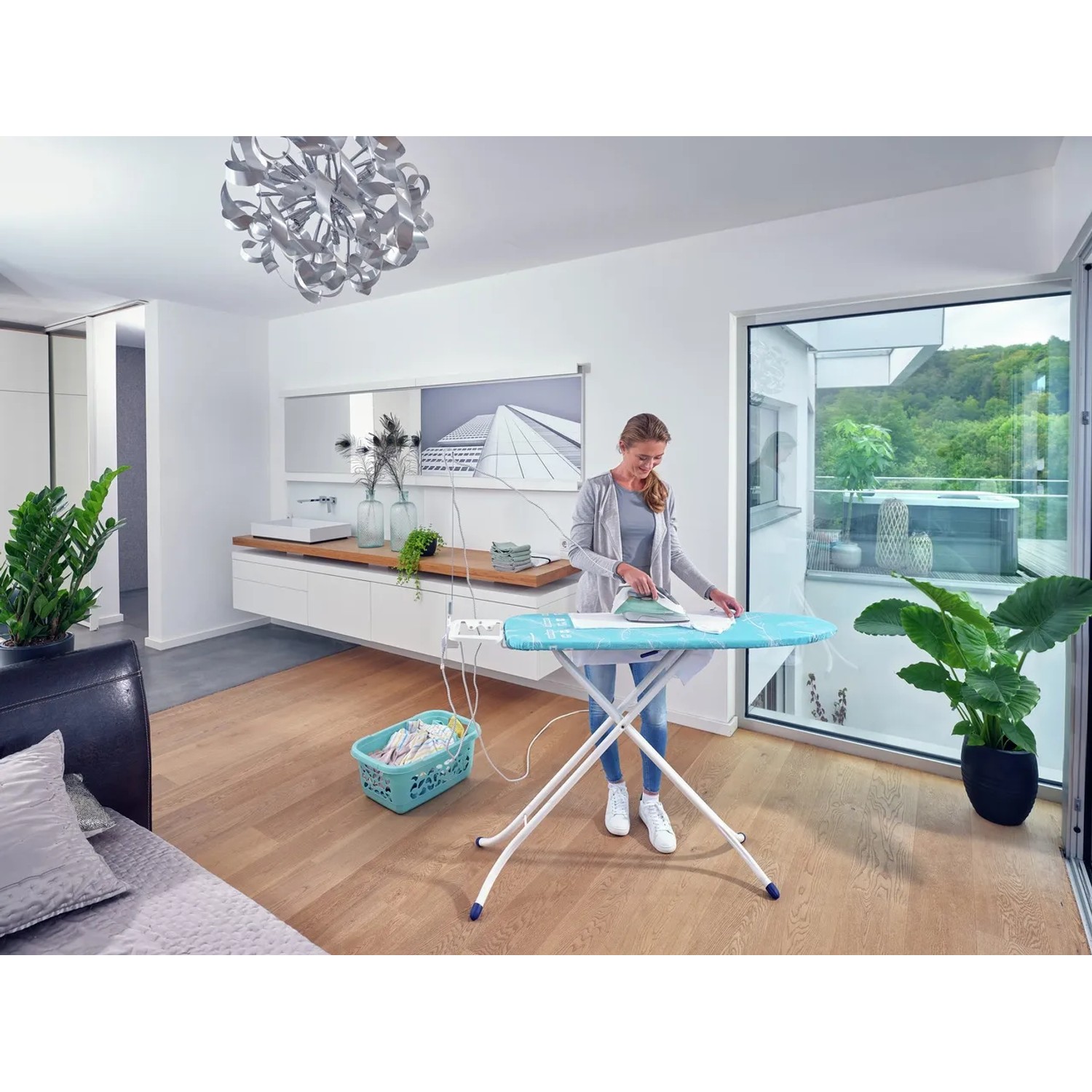 Frau bügelt Wäsche auf dem Leifheit AirBoard Compact M Plus Bügeltisch mit Thermo-Reflect Bezug.