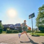 Junge spielt mit Salta Basketballständer Forward (108x362cm) im Garten.