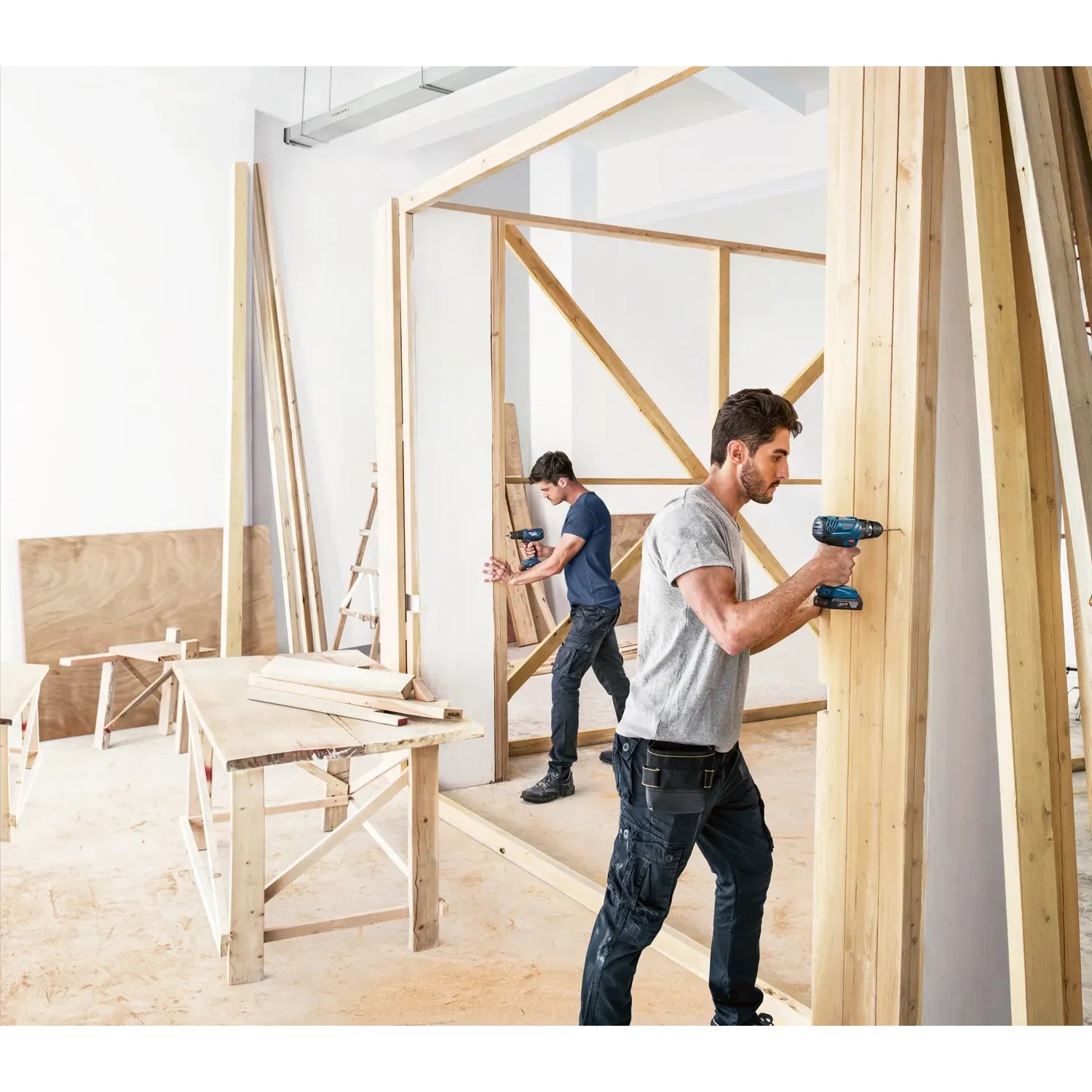 Zwei Handwerker mit Bosch Akkuschraubern GSB 18V-21 im Einsatz beim Holzbau.