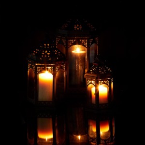 Drei schwarze Metall-Laternen mit orientalischem Muster und brennenden Kerzen. Stimmungsvolle Deko für drinnen & draußen.