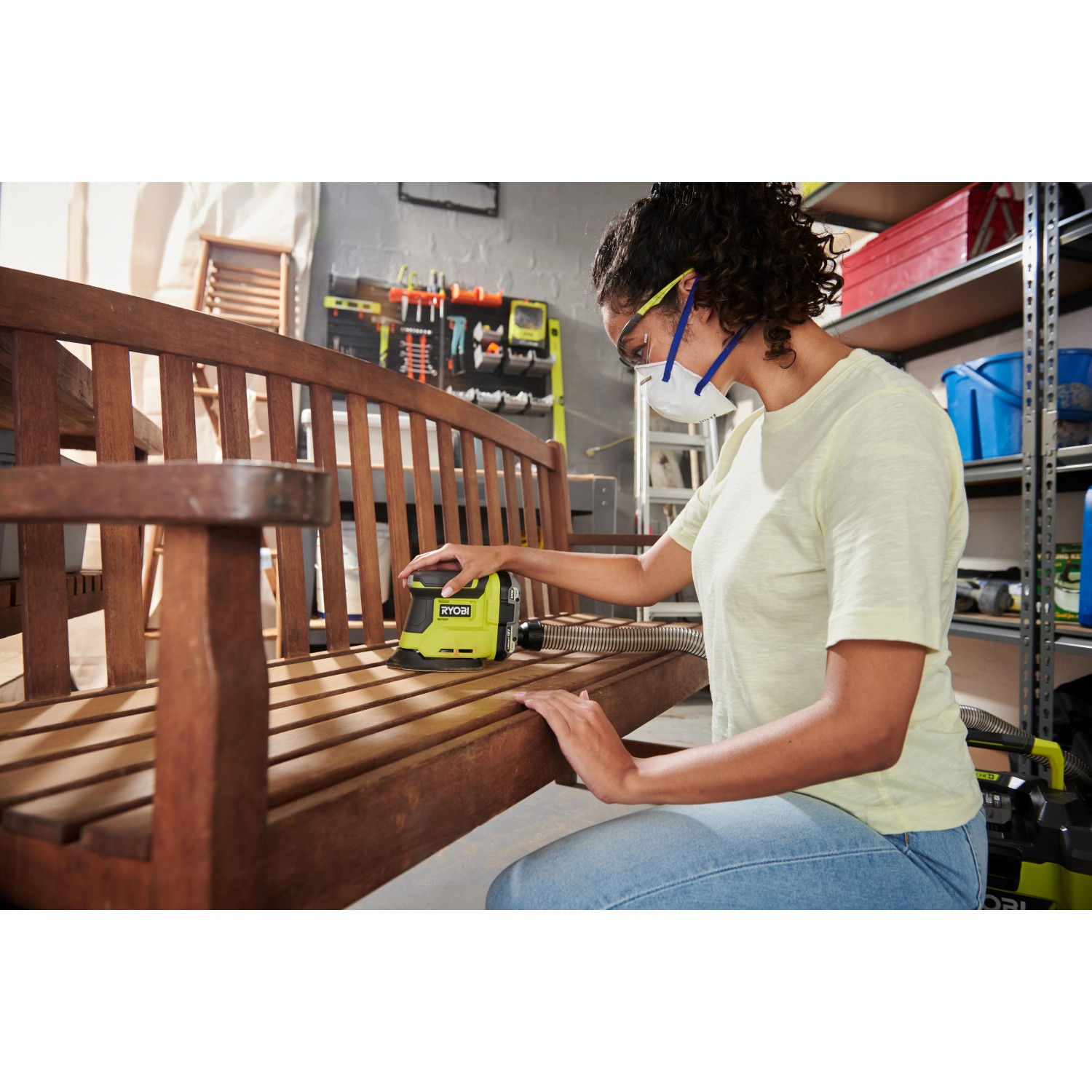 Frau schleift Holzbank mit Ryobi Akku-Delta-Vibrationsschleifer RPS18-0 One+ 18V.