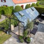Schwarzes Halls Gewächshaus Qube+ 816 mit geöffneten Fenstern im Garten.