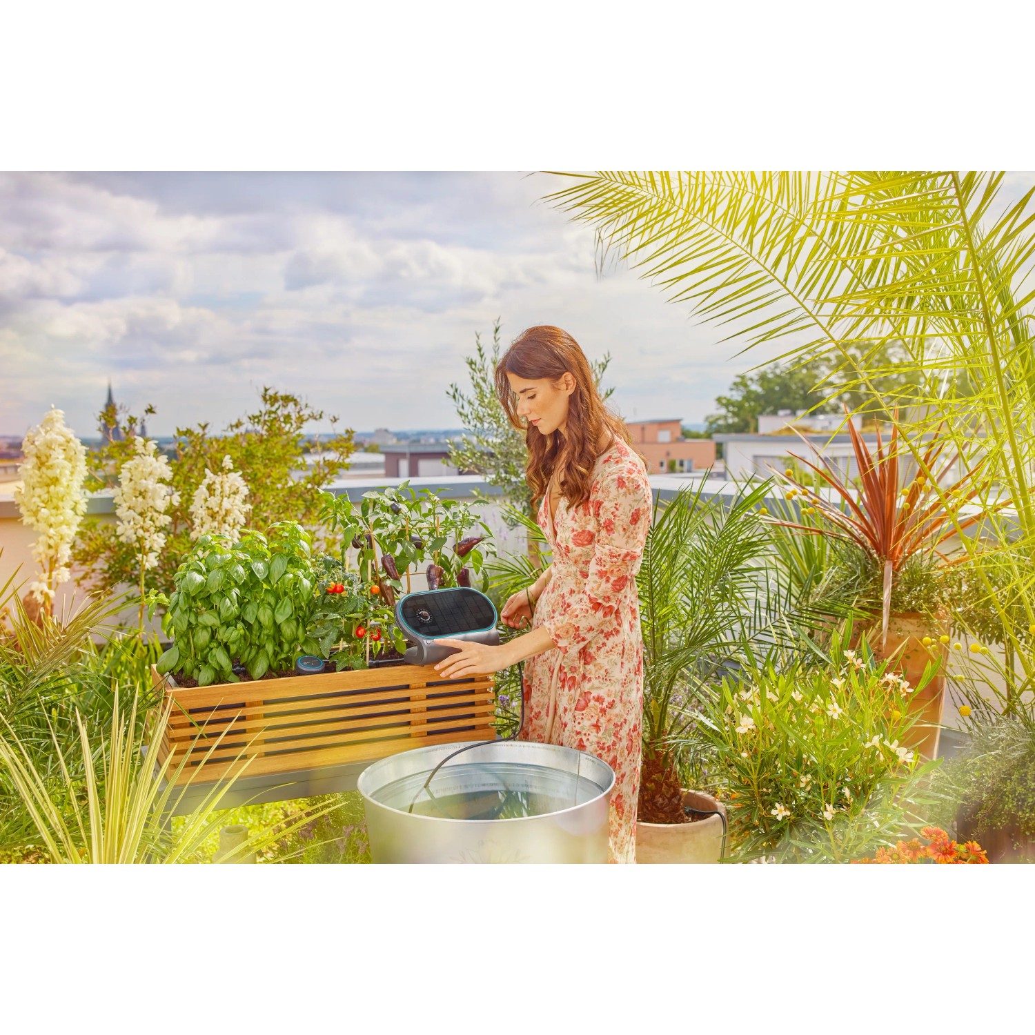 Frau bedient Gardena AquaBloom L Solar-Bewässerung im Garten.