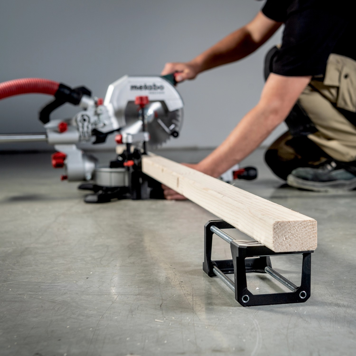 Metabo Kappsäge KGS 305 M mit Zugfunktion beim Sägen eines Holzstücks.