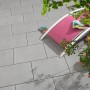 Verlegte, graue Kann Casavera Terrassenplatten (60x40) mit Liegestuhl und Dekoration.
