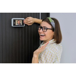 Frau nutzt Basi Digitaler Türspion TS 700 in Silber. Tür mit verchromten Türspion.