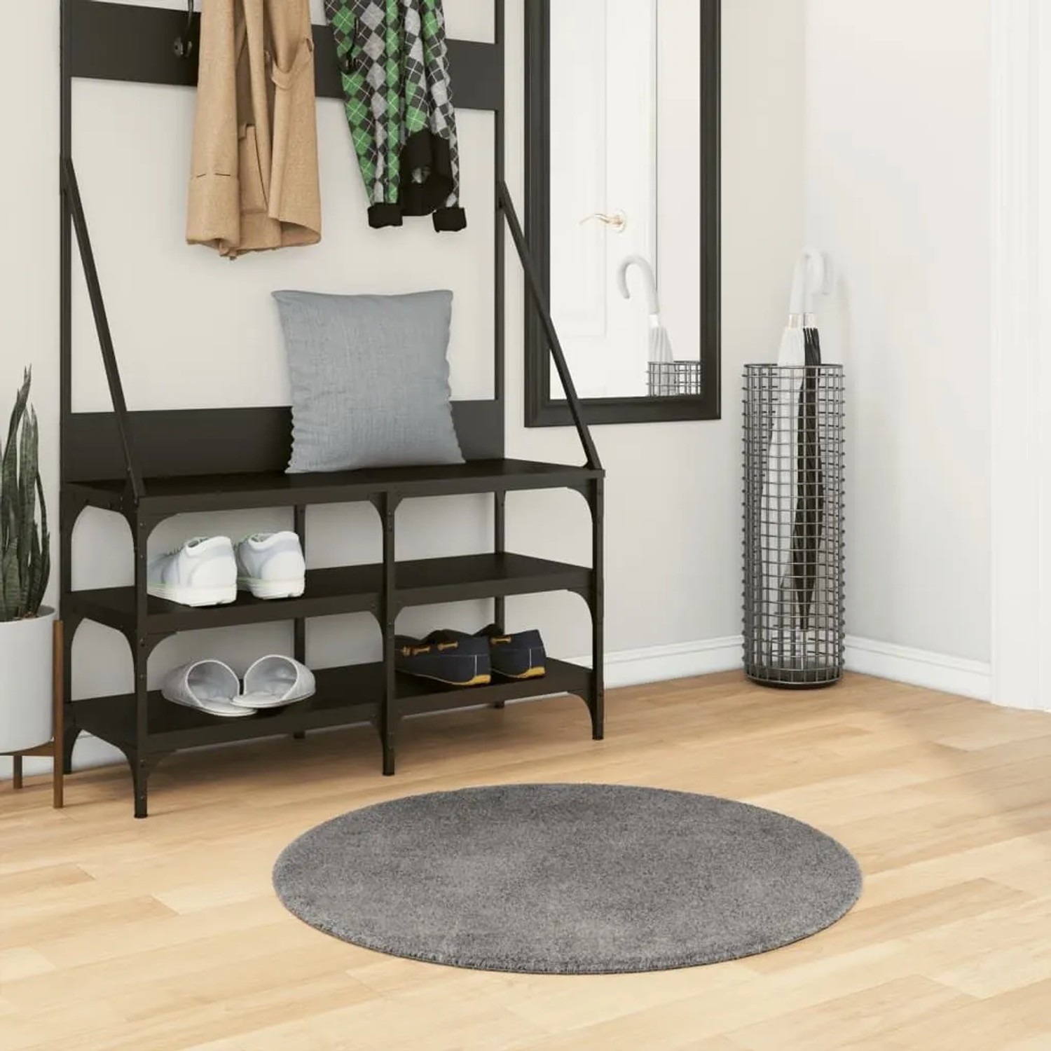 Runder, weicher Anthrazit Kurzflorteppich (Ø 80 cm) auf Holzfußboden im Flur. Ideal für Wohnzimmer.