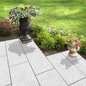 Verlegte Florco Naturstein-Klickfliese Stone Granit XL im Garten mit Dekoration.