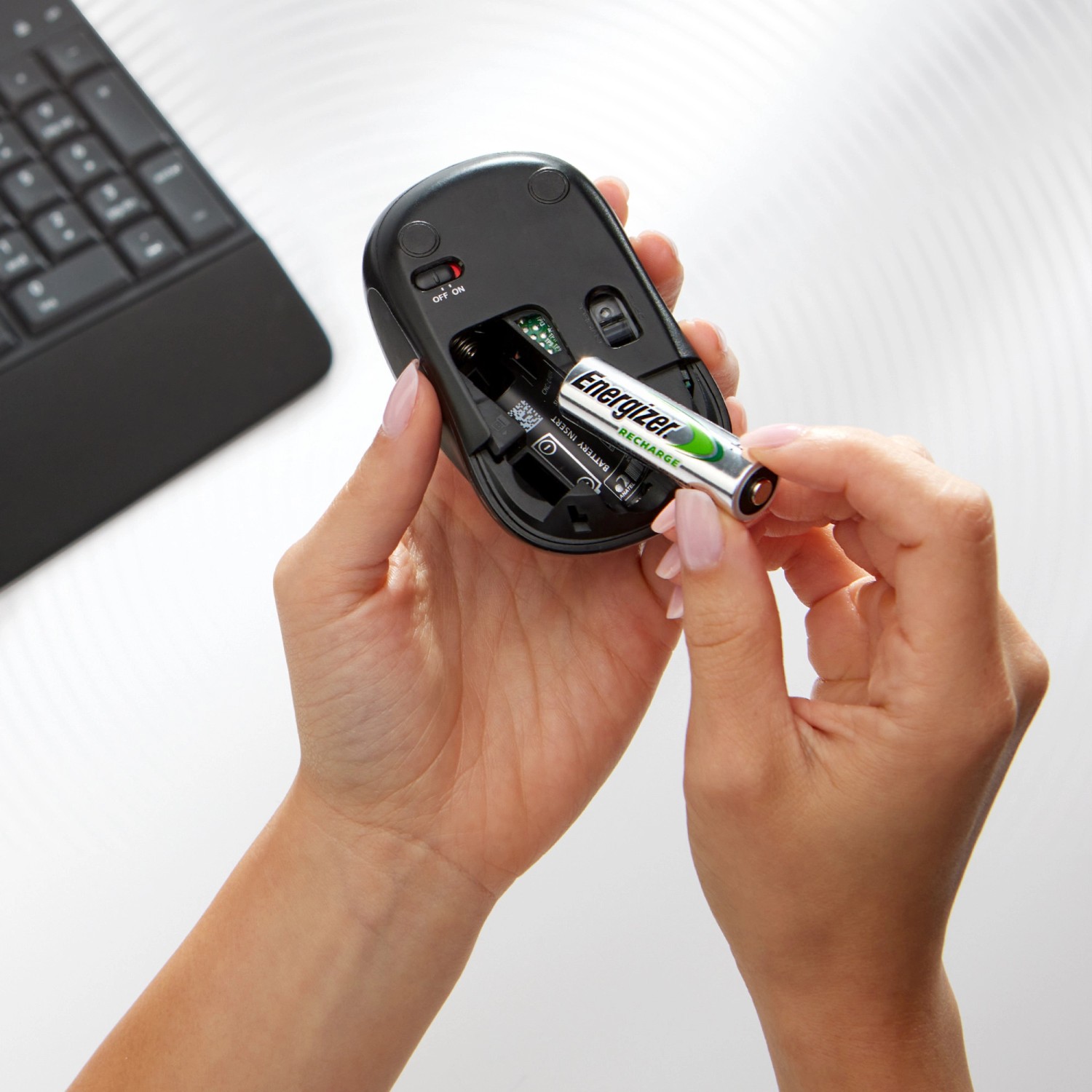 Einsetzen eines Energizer Akkus in eine Computermaus. Power Plus AAA Micro Akku.