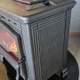 Plamen Gusskaminofen Tena mit Herdplatte, Detailansicht. Kaminofen aus Gusseisen mit Feuer.
