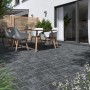 Verlegte Diephaus Pflastersteine Collo Basalt 21x14x7 cm im Außenbereich mit Gartenmöbeln.
