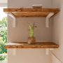 Weiße HEVVA Schwerlast Regalhalterungen tragen zwei braune Holzregale an der Wand. Stabile Möbelausstattung für Regale.