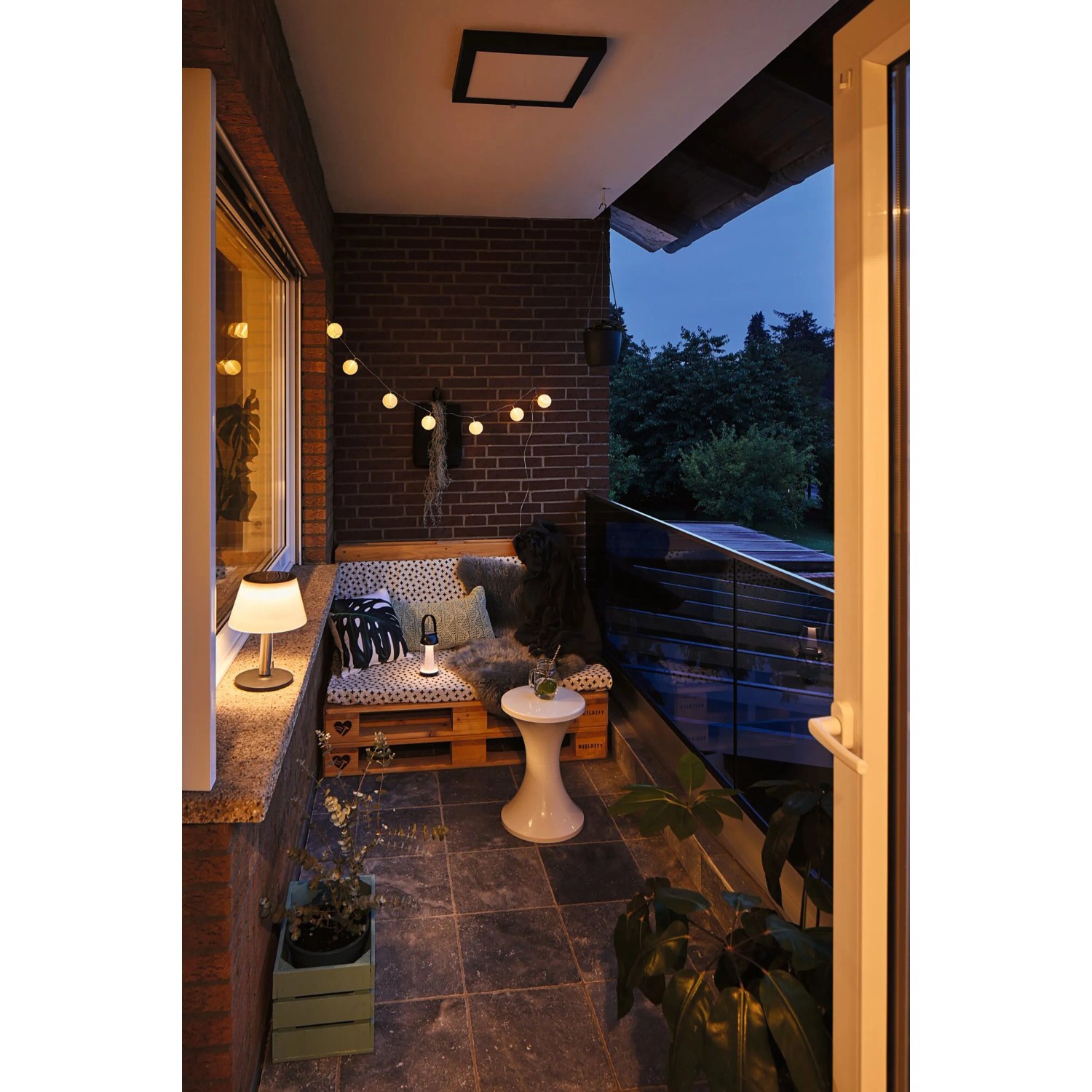 Stimmungsbild: Solar Tischleuchte Lillesol IP44 3000K auf einem Balkon mit gemütlicher Beleuchtung.