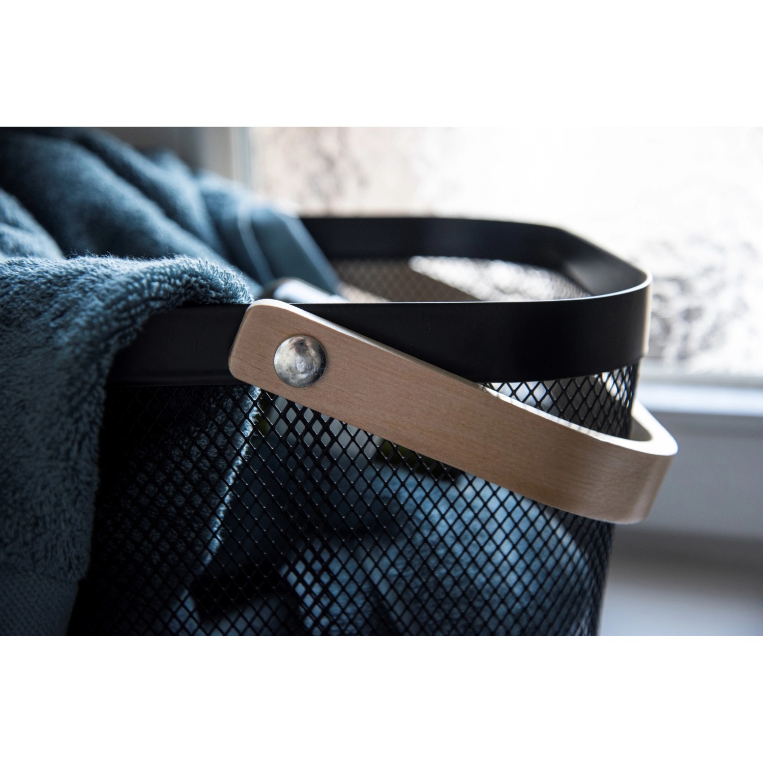 WENKO Badaufbewahrung Bambusa, schwarzer Stahlkorb mit Bambusgriff, gefüllt mit blauem Handtuch.