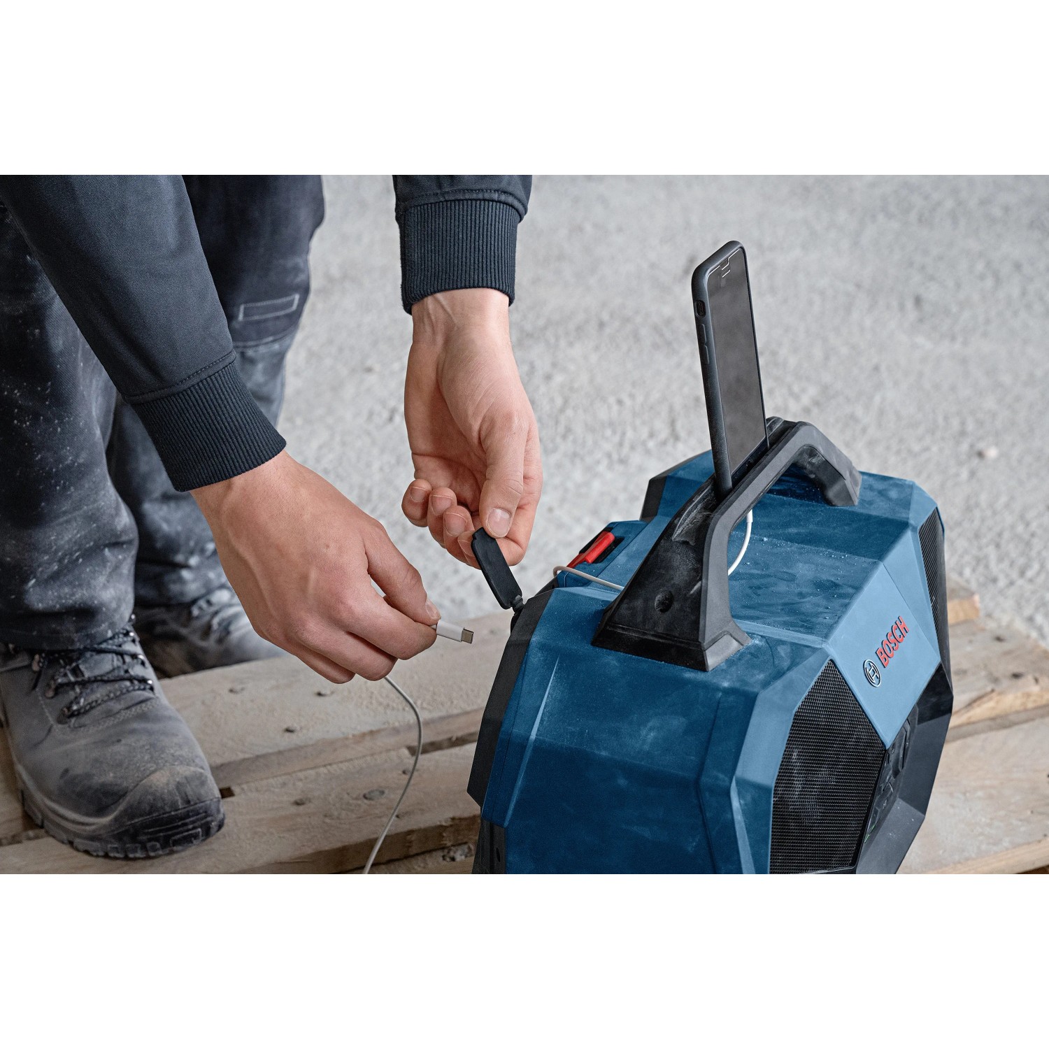 Bosch Professional GPB 18V-6C Bluetooth-Lautsprecher mit Smartphone und USB-Kabel.