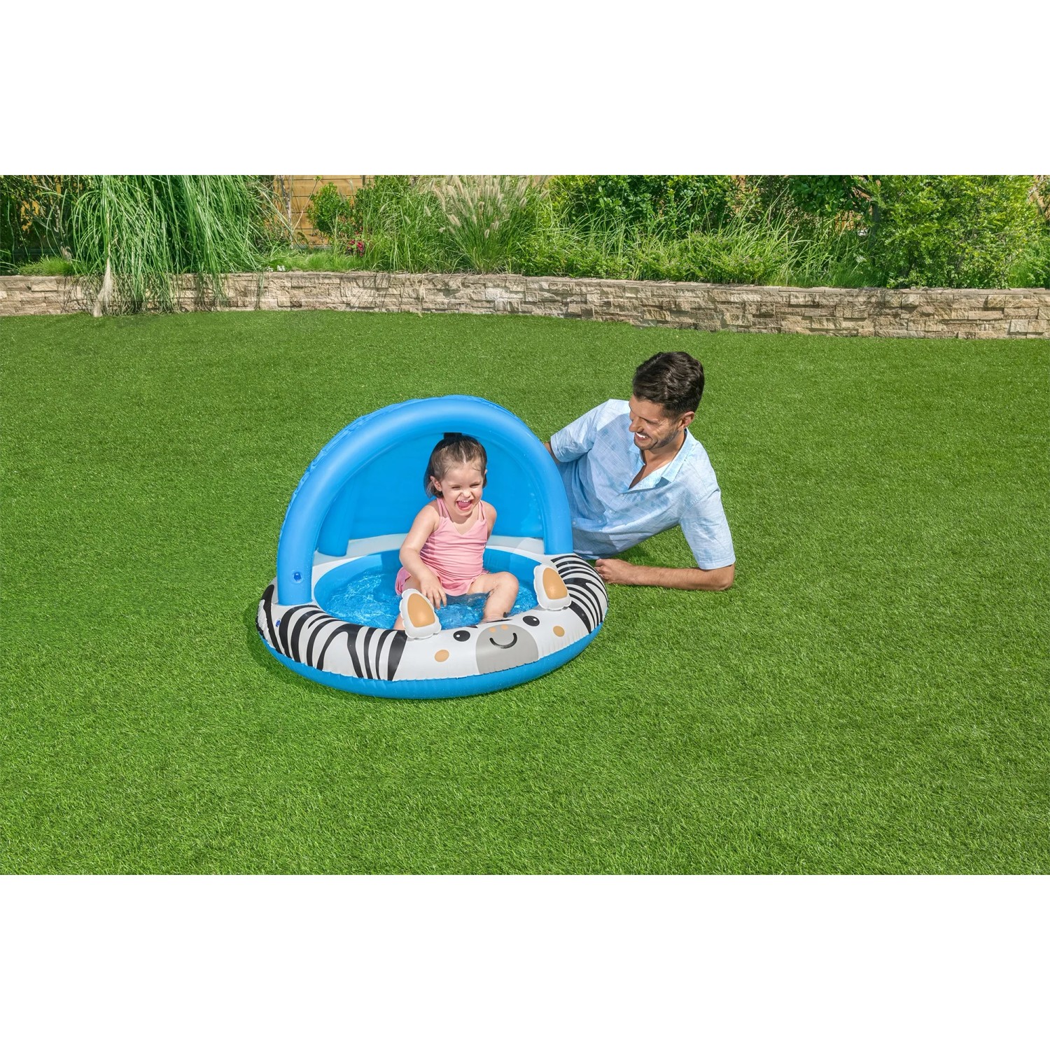 Bestway Planschbecken Safari Sun mit Zebra-Design und Sonnenschutzdach, Kind sitzt im Pool, Erwachsener daneben.
