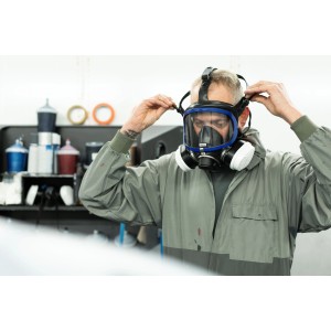 Mann mit Dräger X-plore 5500 Lackiererset (Vollmaske, A2P3-Filter) in Schwarz-Weiß beim Anpassen der Maske.