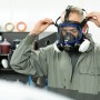 Mann mit Dräger X-plore 5500 Lackiererset (Vollmaske, A2P3-Filter) in Schwarz-Weiß beim Anpassen der Maske.
