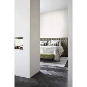 Weiße Vliestapete mit feinen unregelmäßigen Streifen und Sandstruktur im Schlafzimmer. Dekorative Tapete für ein luxuriöses Ambiente.
