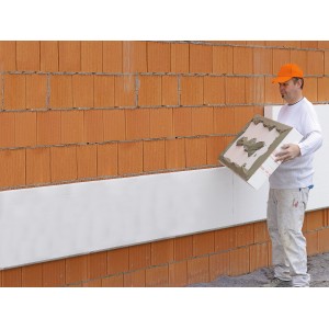Mann verarbeitet WDVS Basis-Paket (160mm) an einer Hauswand. Vollwärmeschutz-System.