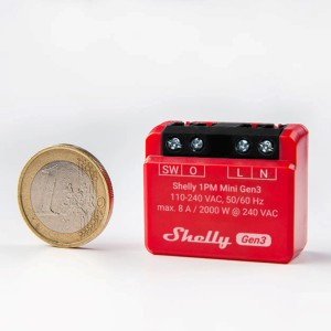 Rotes Shelly Relaismodul Plus 1PM Mini G3 für die Hausautomation, Größenvergleich mit 1-Euro-Münze.