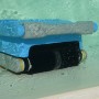 Blauer Akku-Poolroboter Orca 300 CL reinigt Poolboden, -wand und Wasserlinie im Pool.