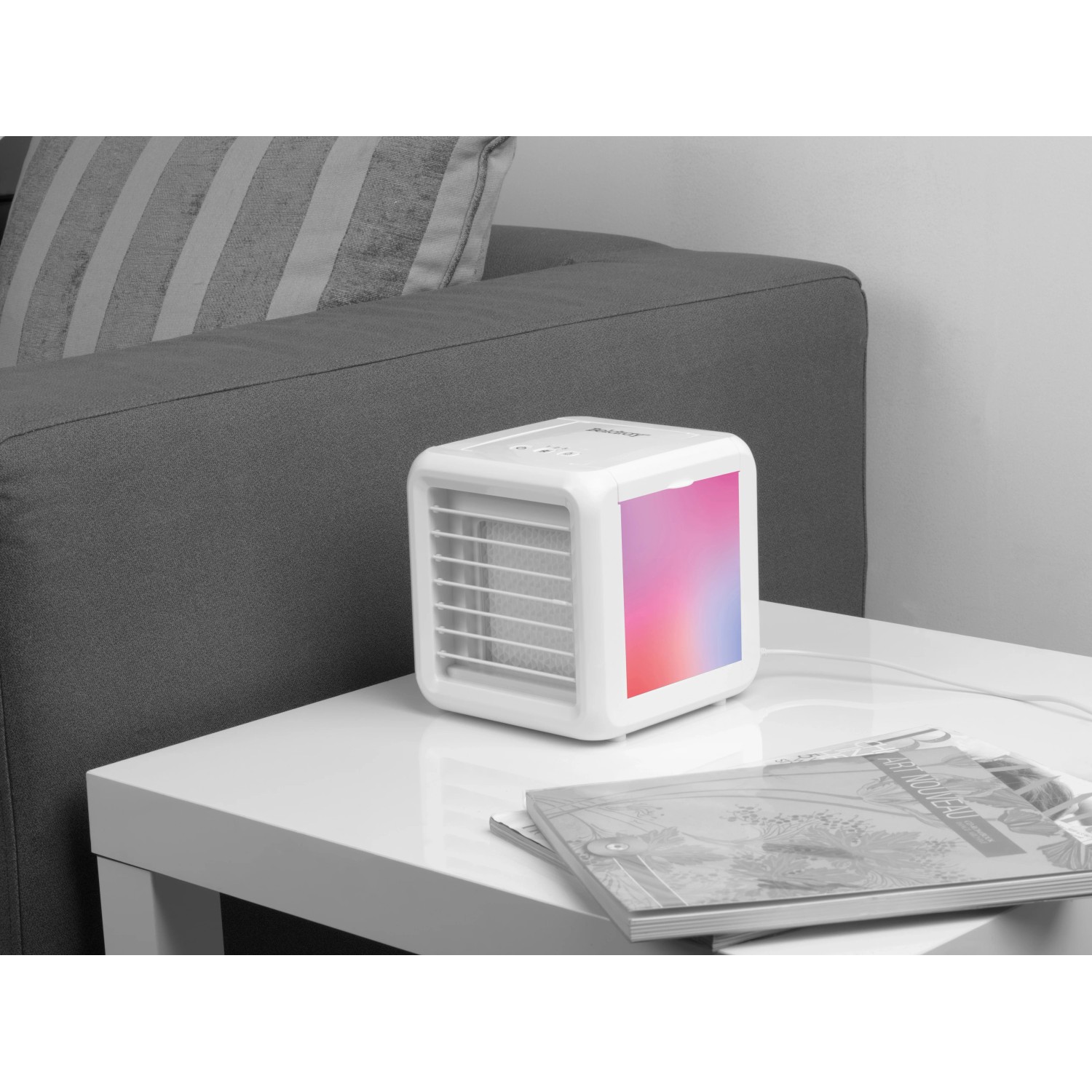 Weißer Mini Luftkühler 7W mit LED Farbwechsel auf Tisch neben Sofa.