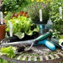 Weiße Kunststoff-Stecketiketten in Töpfen mit Salat, Gurke und Kräutern auf einem Gartentisch. Ideal für Pflanzenbeschriftung.