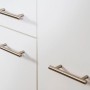 Detailaufnahme: Weiße Küchenzeile mit Edelstahlgriffen, Eiche Sägerau Arbeitsplatte.